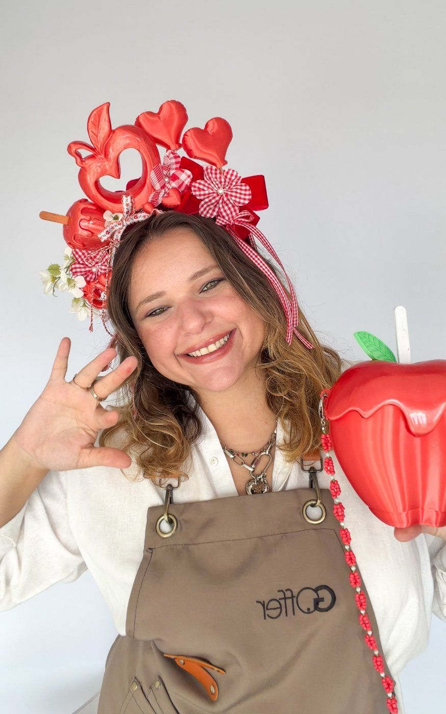 Giovanna Offer no ateliê, com tiara de corações e avental da G. Offer